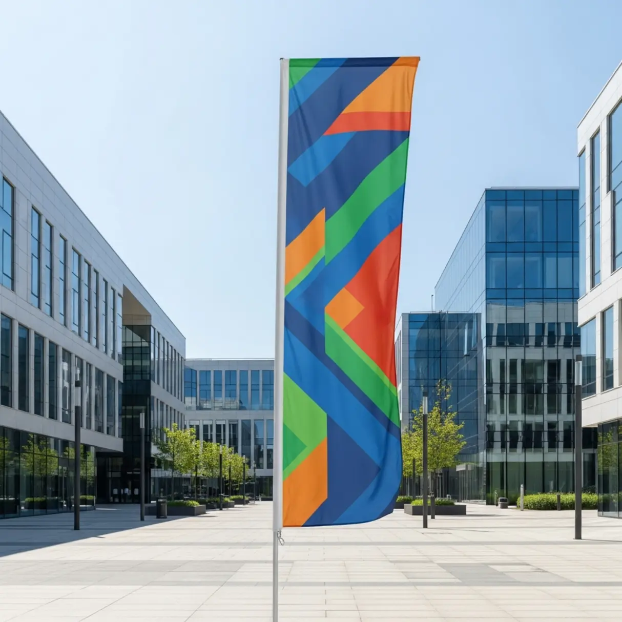 Zdjęcie nowoczesnej flagi reklamowej z abstrakcyjnym wzorem geometrycznym na tle budynków biurowych.